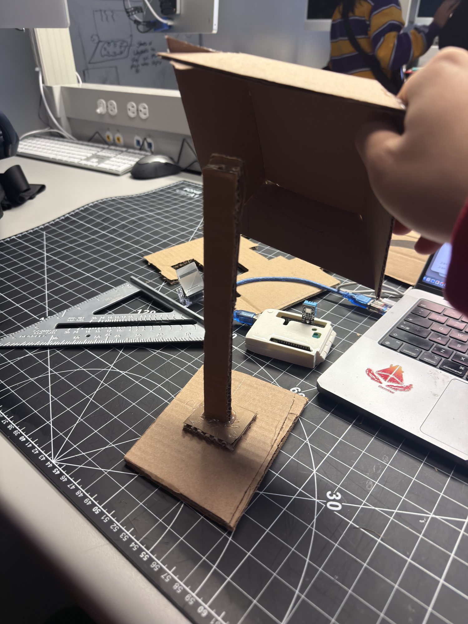 Step 2 — Shade mock-up: trial shade mounted on the post to simulate real torque. Problem: front tilt lifts the base; tipping risk is high. Decision: add a rear wedge brace or a twin-post layout to share the moment.